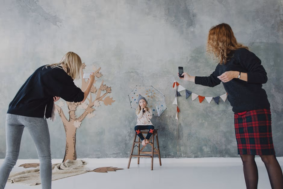 A child holding an umbrella posing for a photo session in a creative studio setup.